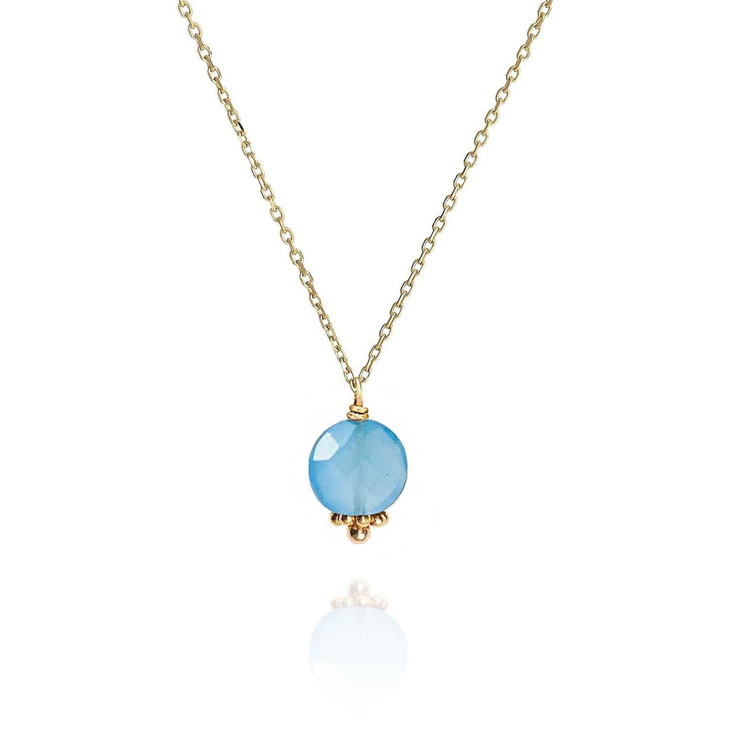 minimalist blue quartz necklace with a faceted flat gem hanging on a 18k gold chain with a hand made indian bead