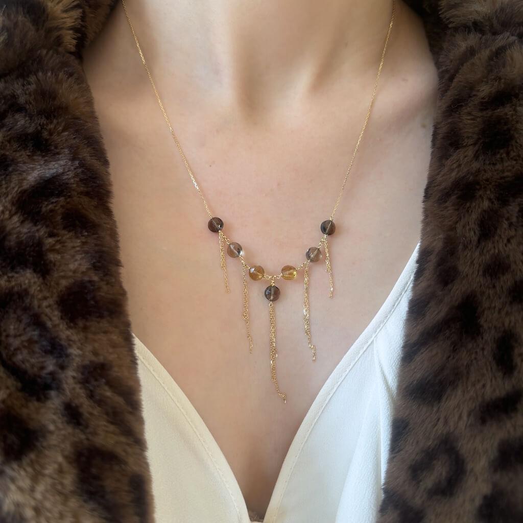 Citrine and smoky quartz gemstone 18k gold necklace with tassel on model with faux fur leopard coat