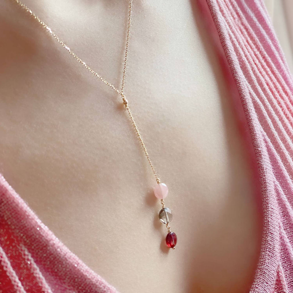 Lariat Necklace with 3 gemstones of Pink , Smoky  quartz  and garnet gemstones on a person wearing a pink garment