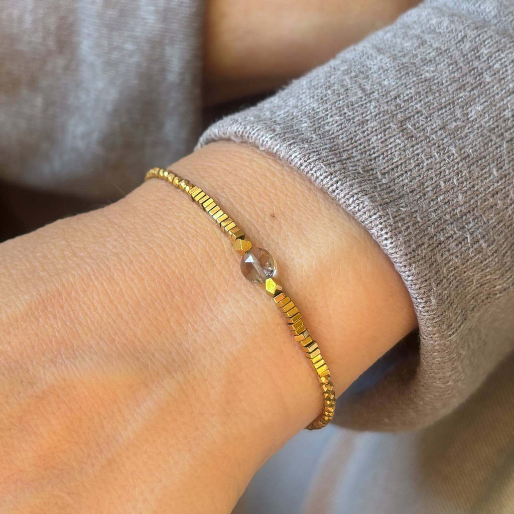 Close-up of a beaded bracelet with smoky quartz and golden Hematite gemstones