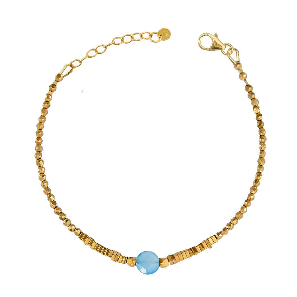 Elegant Hematite Beaded bracelet with a central faceted blue quartz gemstone on a white background. Perle de Lune jewelry