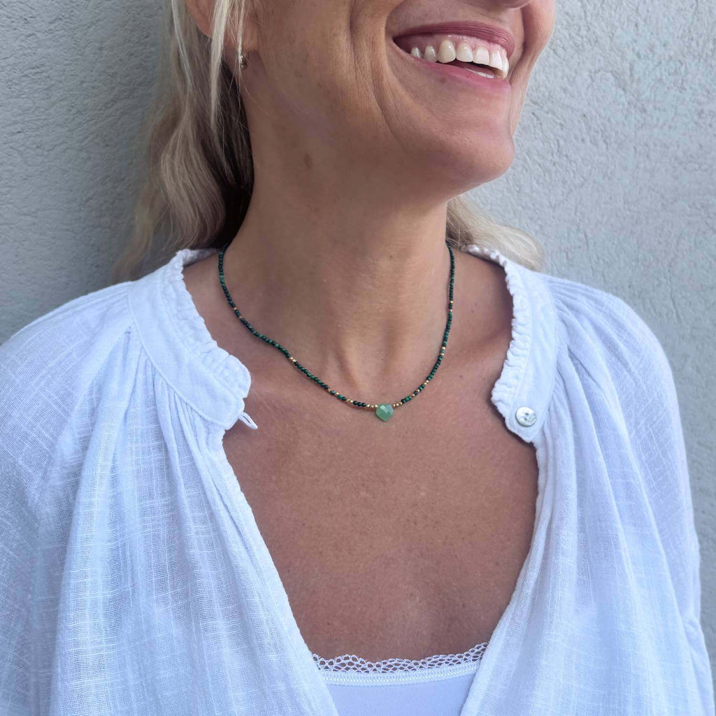 Choker necklace with Chrysoprase bullet gemstone and Malachite beads on a smiling model wearing a white blouse