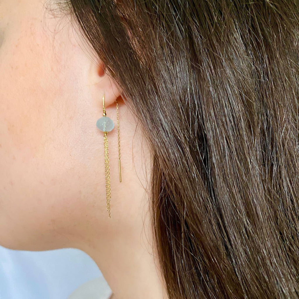 Aquamarine threader earrings with sparkly tassel in 18k Gold on a brunette model, faceted button gemstone, beautiful natural blue milky colour