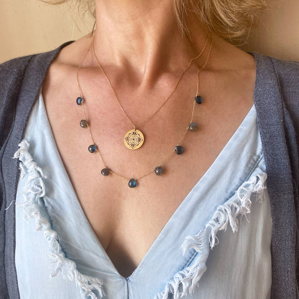 Blue topaz and Labradorite floating drops  18k gold necklace on model with blue dress close up