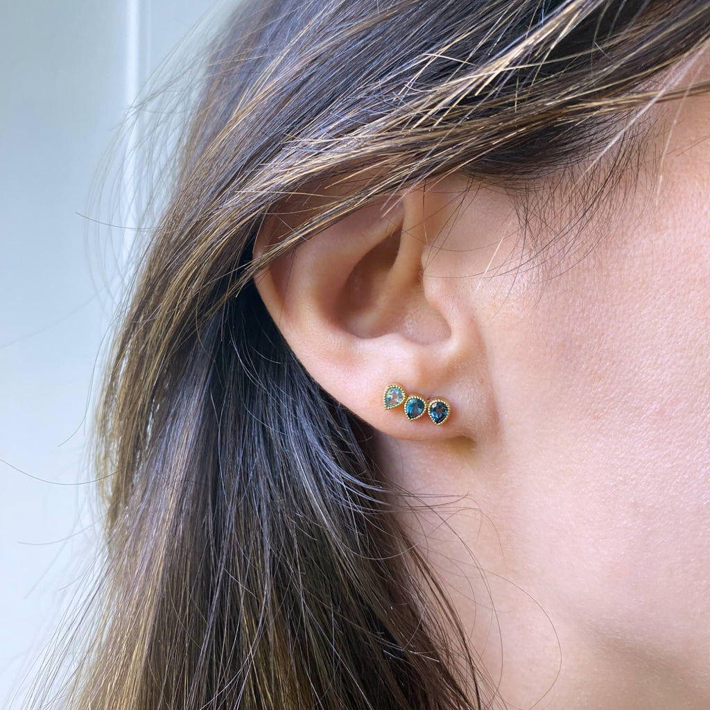 18k Yellow Gold Ear climber for right ear on a model with 3 gemstones of Blue topaz in gradient shades of Swiss blue topaz and London blue topaz