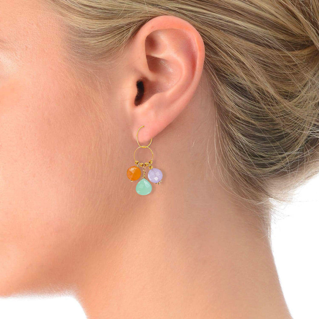 A gemstone charm in 18k gold with a trio of of Carnelian, Chrysoprase & Lavender Jade  on a model ear 